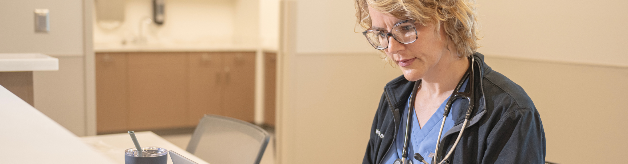 nurse focuses on laptop in a medical setting