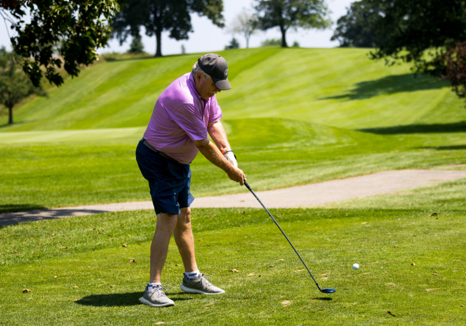 man swings his golf club at a golf ball