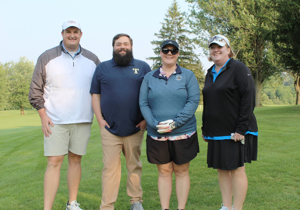 group poses for the camera on the golf course