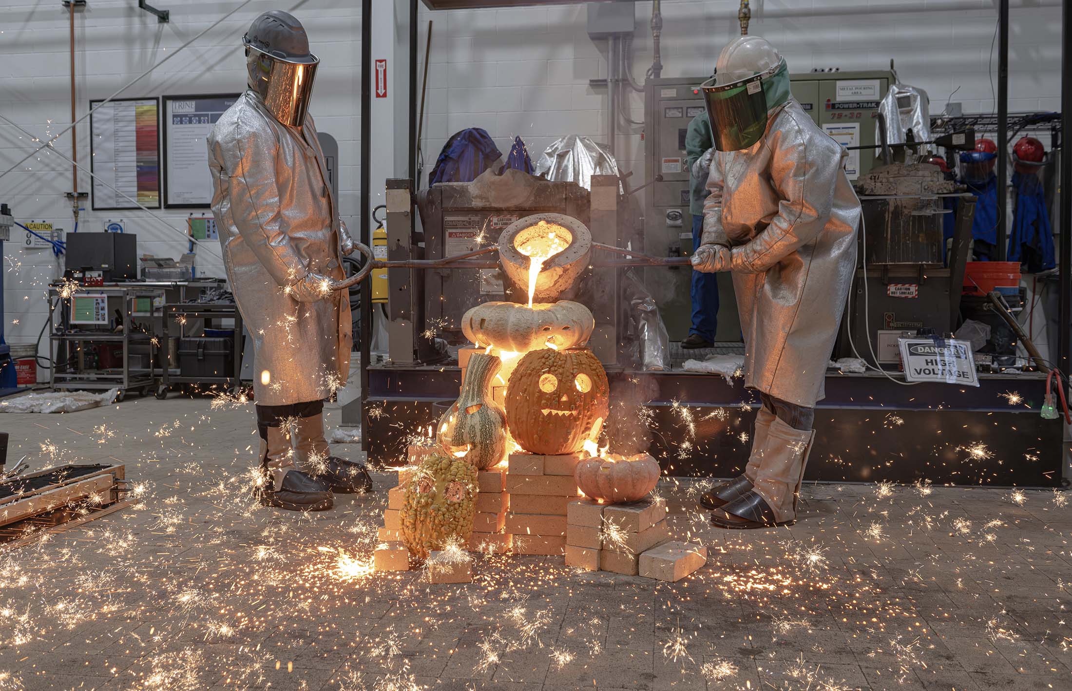 Students pouring molten iron into gourds