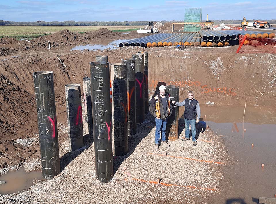 Two people next to bridge piles