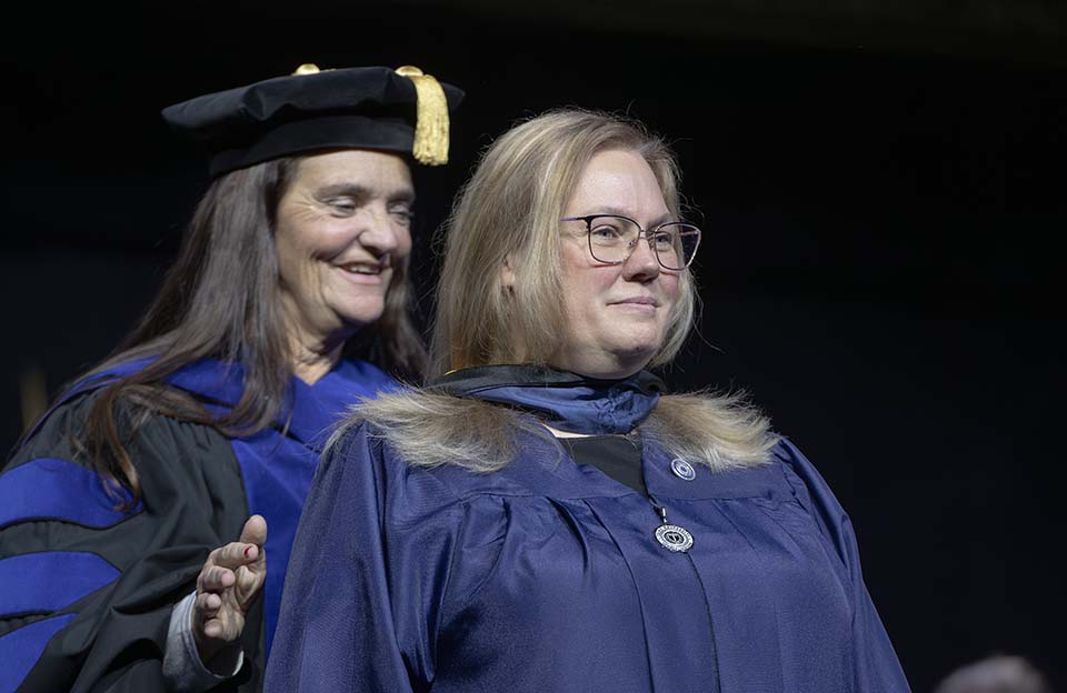 Nursing director placing hood on Master of Science in Nursing graduate