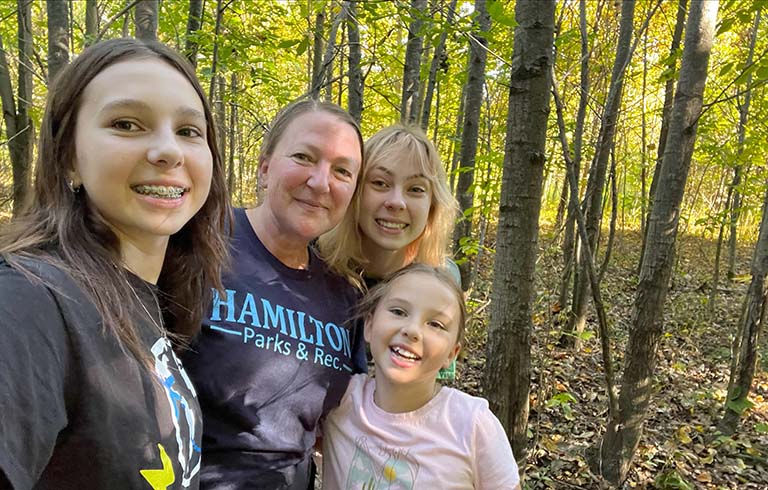 Mom and three daughters in a wooded area on a foraging expedition