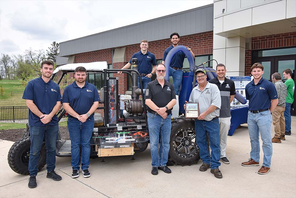 Hydro excavation vehicle with students and supporters