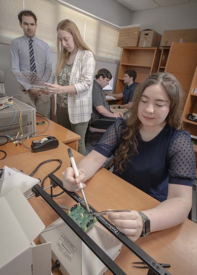 Trine University students and Dr. James Miller working on MEMS resonator research.