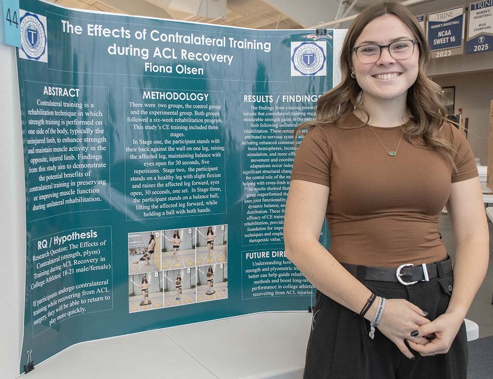 Trine University exercise science student with research poster