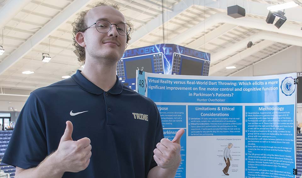 Trine University exercise science student with research poster