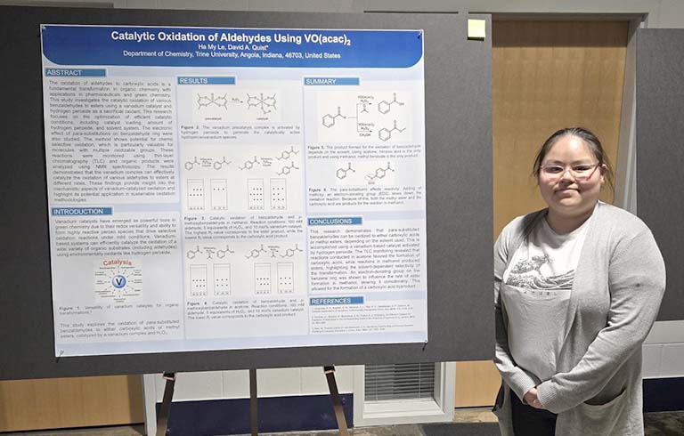 Trine University student with chemistry research poster