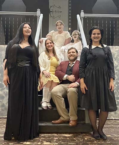 Cast of The Addams Family in costume as Morticia, Alice and Mal Brineke, Ancestors and Wednesday