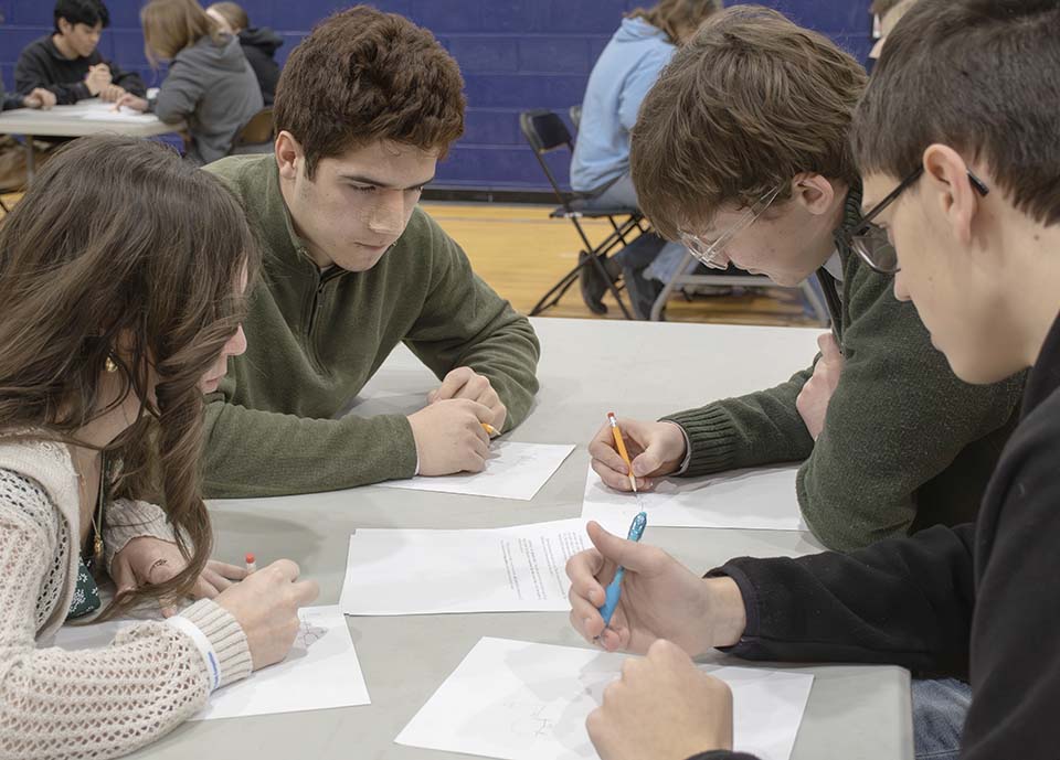 Four students working on math problems