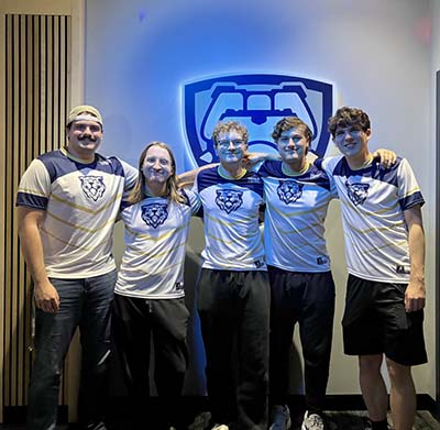 Five esports team members standing in front of stylized bulldog esports logo.