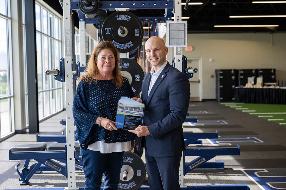 Carri Trine with Dr. Tony Kline standing in front of weight training stations