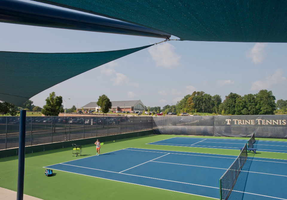 student hitting tennis balls on one of the ryan center tennis courts