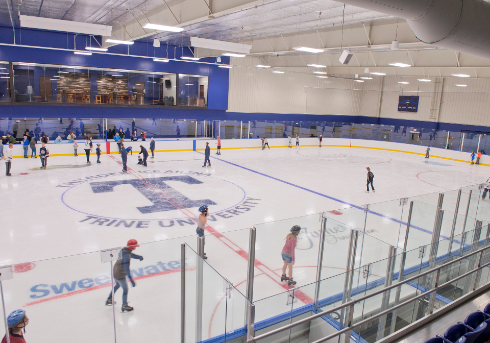 several people skating on an ice rink in the thunder ice arena